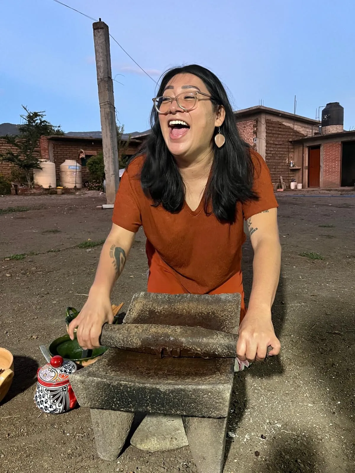 Dora laughing while grinding on a metate